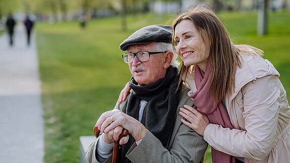 dbb begrüßt gemeinsamen Jahresbetrag für pflegende Angehörige Das Foto zeigt einen glücken Senior mit seiner Tochter im Park.