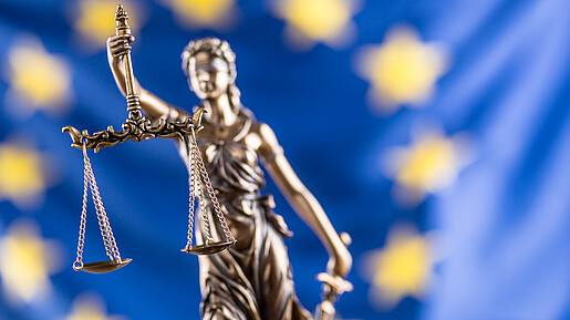 Europäischer Gerichtshof für Menschenrechte zum Tarifeinheitsgesetz Justizia-Statue vor Europaflagge