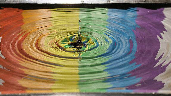 Silberbach zum Diversity-Tag 2025: „Gehen mit gutem Beispiel voran!“ Foto zum Thema "Diversity-Day 2025": Zu sehen sind Regenbogen-Farben, die sich im Wasser spiegeln.