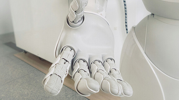 Stellungnahme zum Aktionsplan der Europäischen Kommission für den Kontinent der Künstlichen Intelligenz Nahaufnahme einer weißen Roboterhand