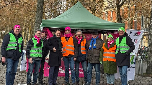 Menschen in bunten Warnwesten demonstrieren auf einem öffentlichen Platz