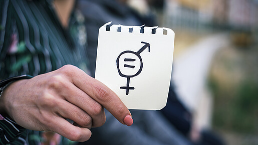 Frau hält Zettel mit Gleichheitssymbol (Symbolbild) Frau hält Zettel mit Gleichheitssymbol (Symbolbild)