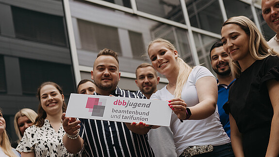 Zu sehen sind Mitglieder der dbb jugend mit einem Schild, auf dem "dbb jugend" steht.