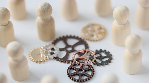 Wooden figures of people with metal gears close up. Hire personnel, team building, teamwork concept. People connection in business.
