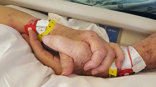Tag der Organspende - Informierte Entscheidung kann Leben schenken Das Foto zeigt zwei Hände - eine einer gesunden Person, eine einer kranken Person.