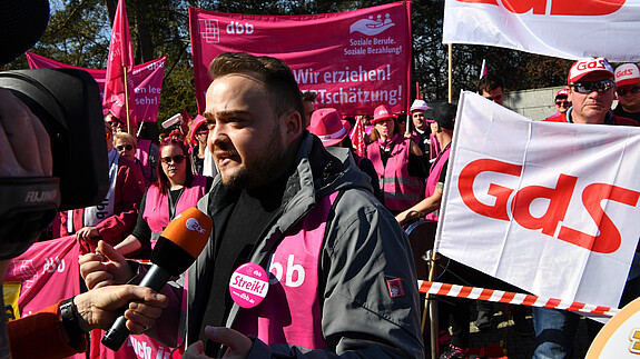 dbb jugend Chef Matthäus Fandrejewski steht vor Demonstrierenden in Potsdam und gibt dem Fernsehsender ZDF ein Interview zu den Tarifverhandlungen für den öffentlichen Dienst von Bund und Kommunen. 