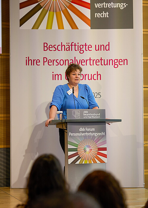 Eine Frau hält einen Vortrag an einem Rednerpult