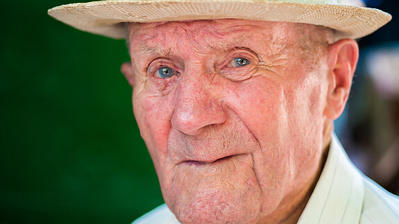 Menschenrechte: Ältere im Focus Very old man portrait with emotions. Grandfather happy and smiling. Portrait: aged, elderly senior. Close-up of a pensive old man in white hat sitting alone outdoors at summer.