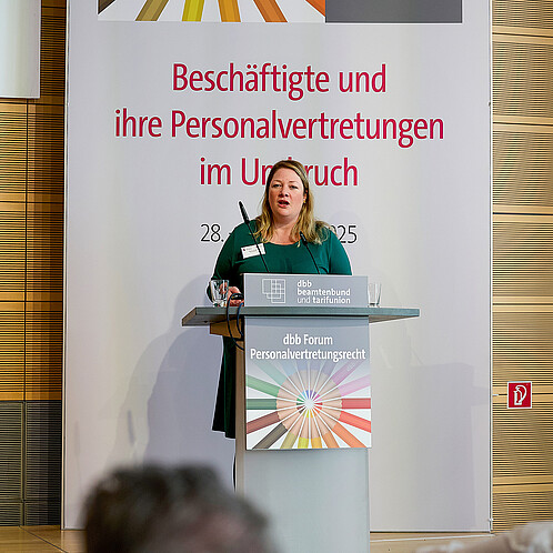 Eine Frau steht hinter einem Rednerpult