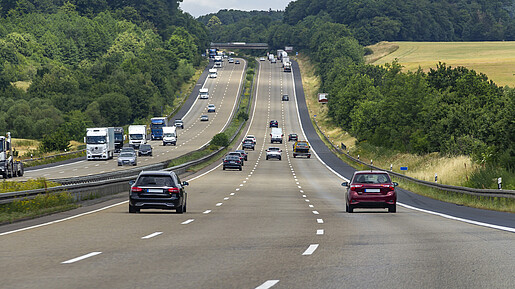 Das Foto zeigt eine dreispurige Autobahn, auf der Autos fahren.