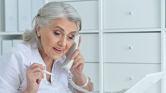 Das Foto zeigt eine Frau im Rentenalter, die am Computer arbeitet.